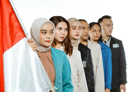 college student standing and holding indonesian flag with looking sidewaysの写真素材
