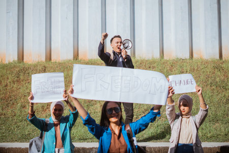 Activists demonstrate for freedom, holding signs and using a speaker to amplify their message