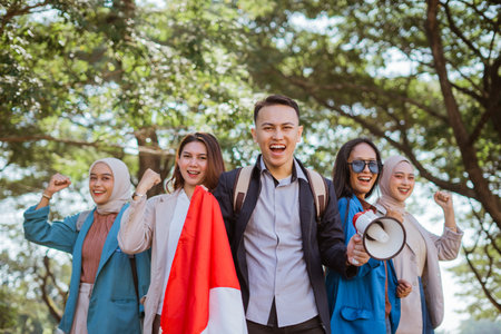 male student leading celebration independence day and holding indonesian flag and megaphoneの写真素材