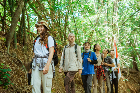 young asian travelers walking or trekking around in a forest wearing outdoor clothesの写真素材