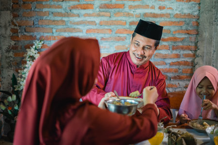 A joyful family joyfully sharing a delicious meal together during a festive occasionの写真素材