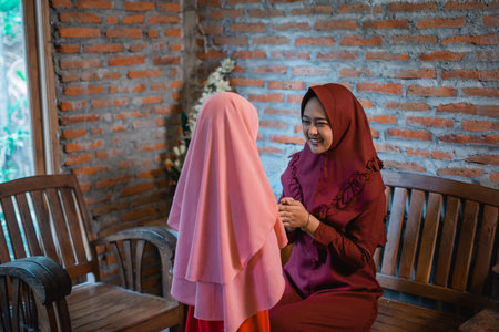 Indonesian Muslim mother shakes hands with daughter during Eid al-Fitr celebration at home