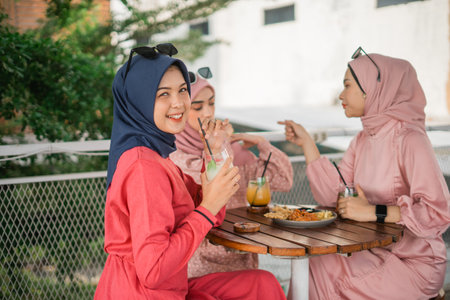 Women socializing with drinks in a trendy outdoor cafの写真素材