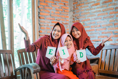 A family joyfully gathers to celebrate Eid, surrounded by colorful signs and cheerful smilesの写真素材