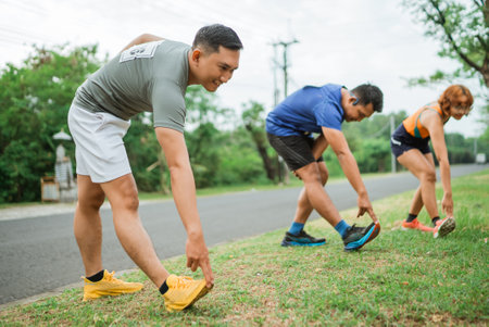 athletic male stretching before running on the marathon trackの写真素材