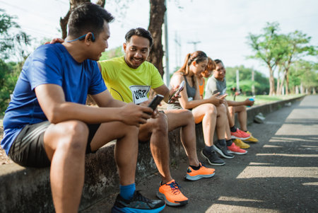 group of athlete taking a break after running and conversating with each otherの写真素材