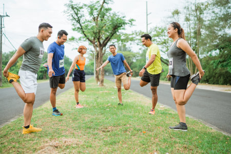 marathon runners in sportswear warming up together before competitionの写真素材