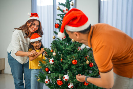 little family having fun decorating christmas tree togetherの写真素材