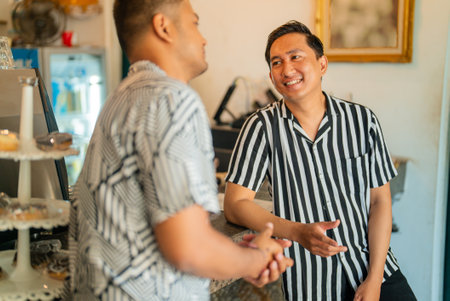 Two men sharing a friendly moment in a vibrant caf atmosphereの写真素材