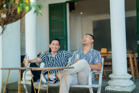 Two friends laughing and enjoying their time at a cafの写真素材