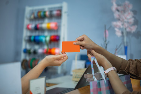 Woman hands over credit card to pay at souvenir shop counter