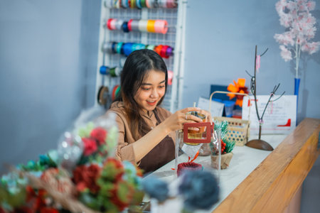 young woman shopkeeper holding items for gifts at her shopの写真素材