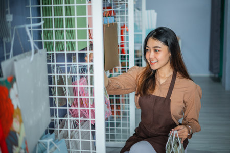 Female sales assistant arranging display items in her shopの写真素材