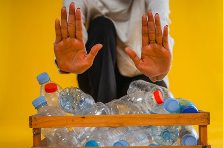 cropped view prohibit hand gesture and plastic bottle in wooden box storage, recycle conceptの写真素材