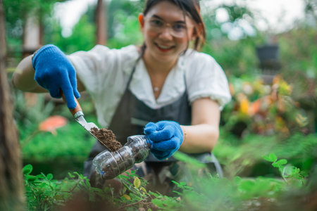 selective focus photo of happy woman gardening using recycled plastic bottleの写真素材