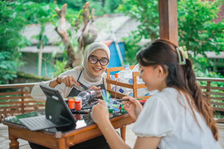 asian women watching upcycling plastic bottle tutorial in tablet together