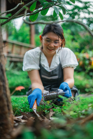 asian woman reuse plastic bottle waste for gardening, recycle conceptの写真素材