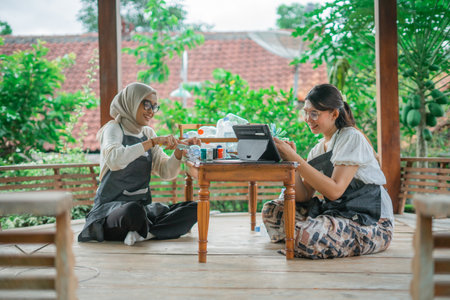 asian women making recycled plastic bottle craft togetherの写真素材