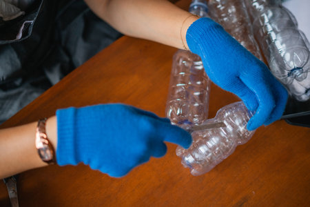 crop view of woman hand holding cutter for cutting plastic bottleの写真素材