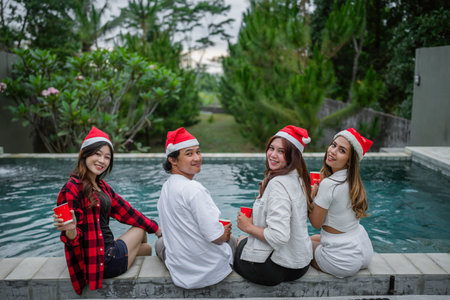 rear view of young people enjoying christmas pool party togetherの写真素材