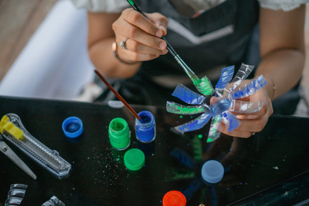 crop view woman hand paint plastic bottle handcraft