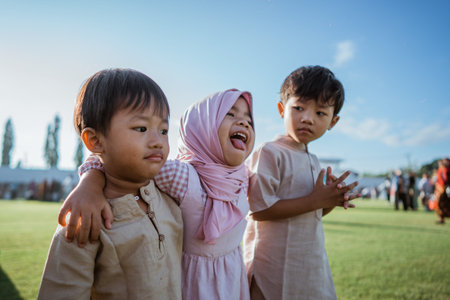 Three joyful children in colorful outfits enjoy a sunny day outdoors, filled with laughter