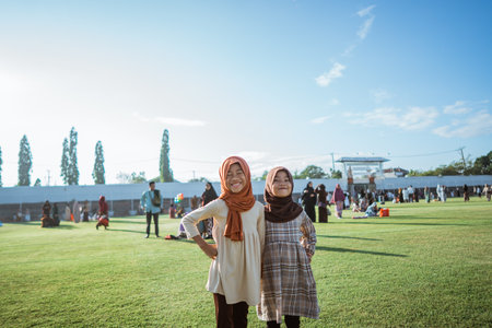 Friends smiling and posing together on a sunny day at a joyful community gatheringの写真素材