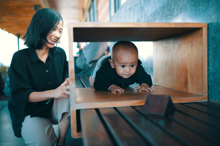 A joyful mother watches her baby explore in a unique play environment for their development