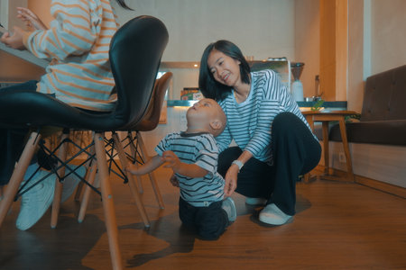 A loving mother playfully interacts with her delightful child in a warm, cozy homeの写真素材