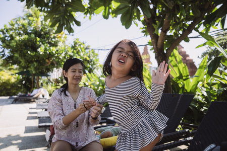 A lively child is joyfully enjoying some outdoor playtime with a family member in natureの写真素材