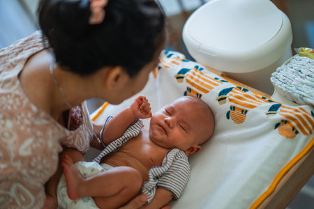 A tender interaction between a mother and her infant in a warm, loving home environmentの写真素材