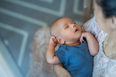 A serene and tranquil scene of a mother lovingly and gently holding her sleeping baby closeの写真素材