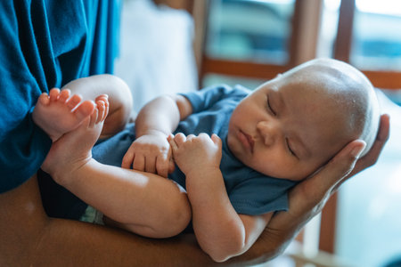 A serene baby sleeps peacefully, cradled in the gentle embrace of a loving caregiver