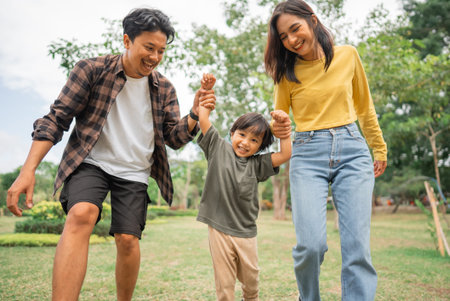 happy little boy with mom and dad on a walk in the park