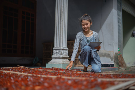 A young child gathers fresh fruit, showcasing agricultural tradition.の写真素材