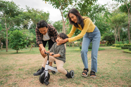 mom holds boys cheek during bike ride with dad outdoorsの写真素材