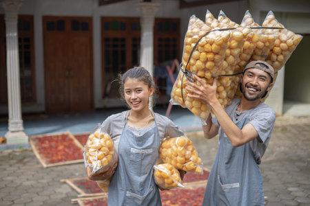 Cheerful people happily pose with delicious snacks in a vibrant, colorful environmentの写真素材