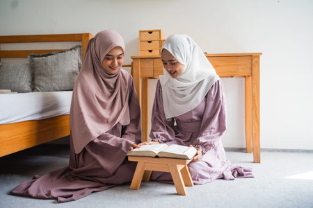 two young muslim woman learning together Quran in the bedroom