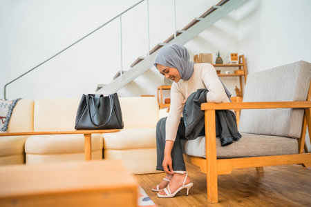 woman wearing shoes getting ready before work sitting in a chairの写真素材