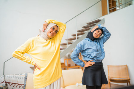 Two cheerful women wearing colorful outfits are striking fun and dynamic poses indoors
