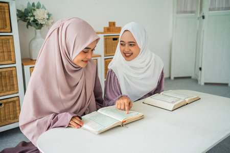 Friends study together, sharing knowledge in a cozy, bright space that fosters collaborationの写真素材