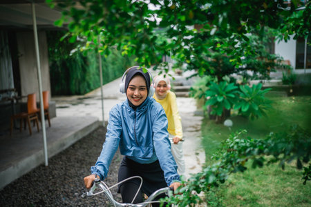 beautiful woman in hijab with headphones on bikeの写真素材