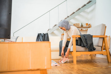A woman thoughtfully prepares herself for the day in a stylish and contemporary living roomの写真素材