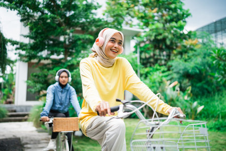 Two friends joyfully riding bicycles in a vibrant park, enjoying the beautiful sceneryの写真素材
