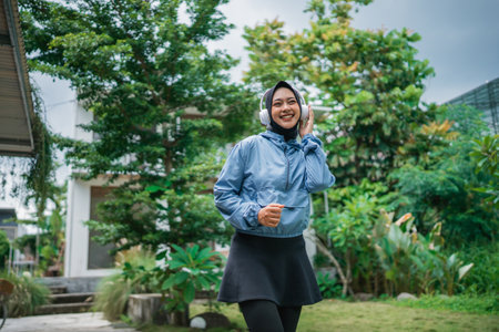 A cheerful and happy woman enjoying a refreshing drink in a lush, vibrant garden settingの写真素材