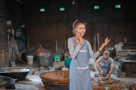 A skilled woman expertly oversees food preparation in a charming, rustic kitchenの写真素材