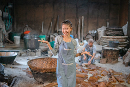 A joyful woman enthusiastically engages in meaningful artisan work in a quaint workshopの写真素材