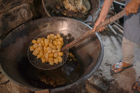 Dumplings sizzle in hot oil, creating a vibrant cooking scene and a delicious aromaの写真素材