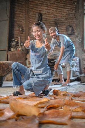 Two artisans joyfully create beautiful clay works in a rustic setting, showing their craftsmanshipの写真素材
