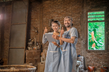 Two artisans proudly display their vibrant pottery in a rustic studio, showcasing their skills